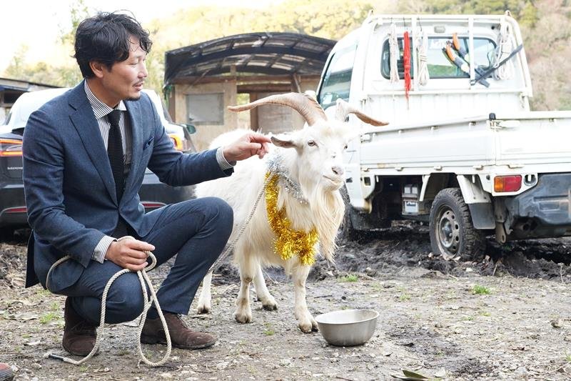 金銀の飾りでおめかしした迷子ヤギの「まーちゃん」と、今後も飼育することを決めた宇佐美さん＝大多喜町
