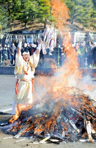 火柱が上がる炉に護摩札を勢いよく投げ入れる成田山新勝寺の僧侶＝２８日、成田市