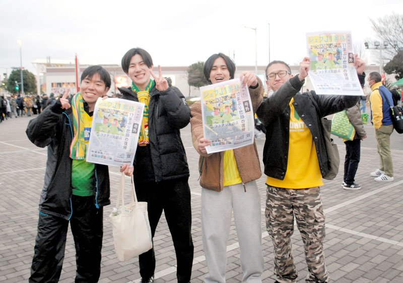 千葉日報の号外を手に笑顔を見せるサポーターたち＝１３日午後４時２５分ごろ、千葉市中央区のフクダ電子アリーナ前