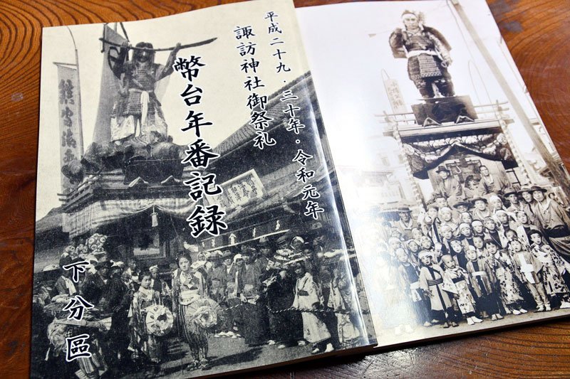 下分区が刊行した「弊台年番記録」。表紙（左）は佐原の大祭最古の写真とされる明治４２年撮影、下分区が初めて年番を務めた本祭の年のもの＝香取市

