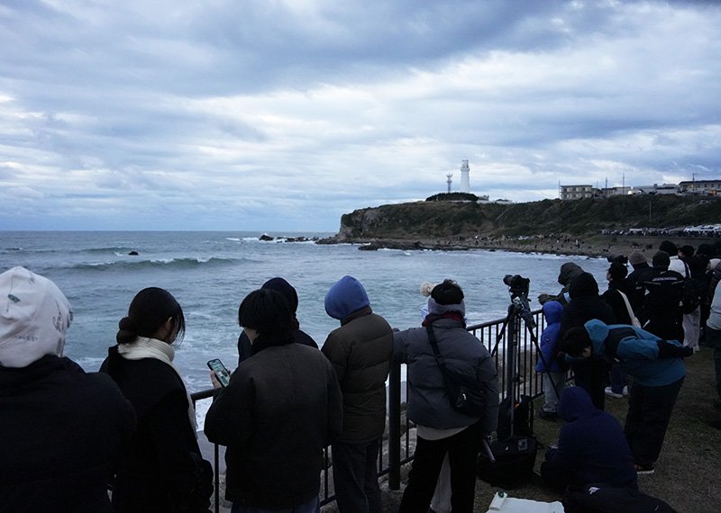 犬吠埼灯台近くの海岸に集まった人たち。雲に覆われ「日本一早い初日の出」は見られなかった＝１日午前６時４６分、銚子市