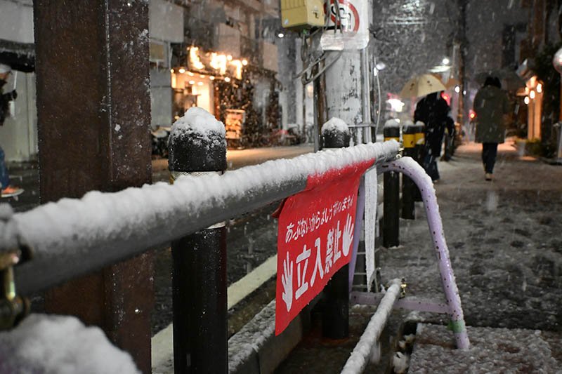 雪が降る中歩く人たち＝２日午後８時２０分ごろ、市川市
