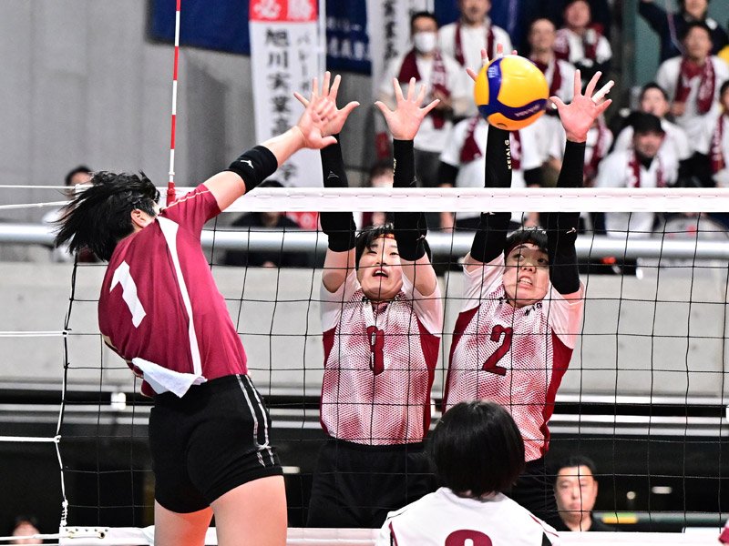 旭川実―敬愛学園　第２セット、ブロックに跳ぶ敬愛学園の根本（２）と大久保（８）＝東京体育館