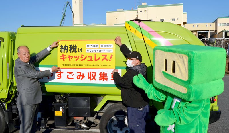 キャッシュレス納税の活用を呼びかけるステッカーを貼る寄主会長（左）ら＝市原市