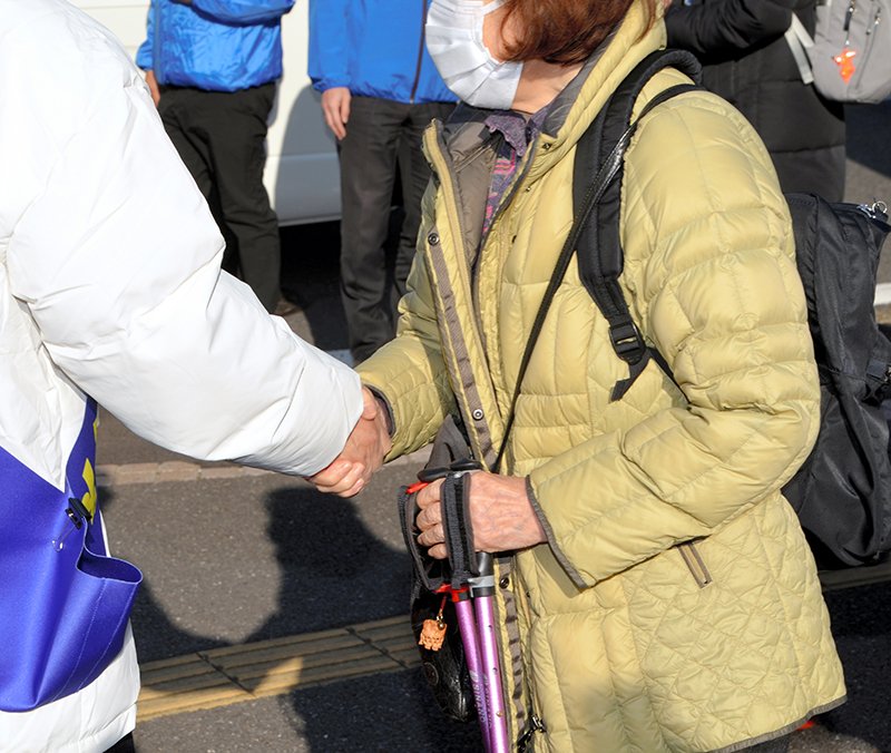 支持者（右）と握手をする候補者＝２７日、千葉市緑区
