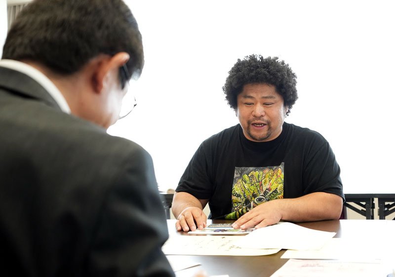 規格外トウモロコシの蒸留酒製造事業について説明する坂尾さん＝銚子市役所