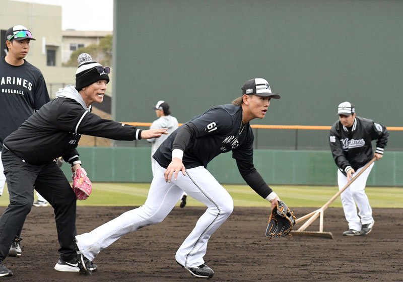 松井臨時コーチ（左から２人目）に教わりながら三塁でノックを受ける千葉ロッテ・山本（中央）＝都城