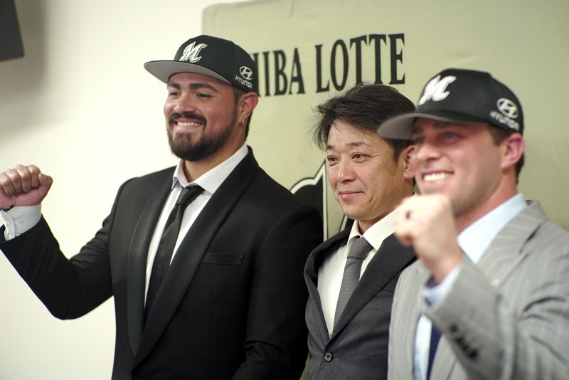 新外国人投手の千葉ロッテ・カスティーヨ（左）らと写真に納まるサブロー監督（中央）