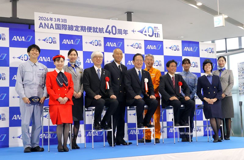 ＡＮＡの国際線定期便の就航４０周年を祝う式典に登場した現役スタッフや同社の井上社長（前列中央）ら＝３日、成田市の成田空港