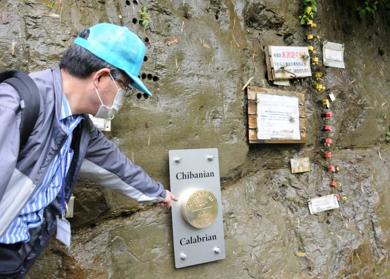 チバニアンの現地に設置された「ゴールデンスパイク」を指差すボランディアガイド＝２０２１年５月、市原市田淵