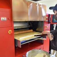 オーブンで真剣な表情でバウムクーヘンを焼く店長の前田さん
