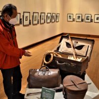 アンデルセン童話の各場面を描いた絵が並ぶ会場。中央はアンデルセンが残した旅行具の複製
