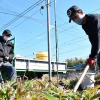 梨の苗木を植える元樹さん（右）の作業を温かく見守る好一さん