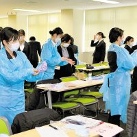 コロナ感染防止の対策として医療用ガウンの着脱練習をする新入職員＝１日、千葉市中央区の千葉大病院