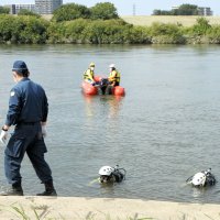 南さんの帽子が見つかった江戸川取水口付近を捜索する警察官＝９月３０日午前１０時４５分ごろ、松戸市