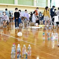 ペットボトルボウリングに挑戦する高齢者
