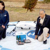ドローンで届けられた商品を受け取った大沢地区の鈴木さん（右）
