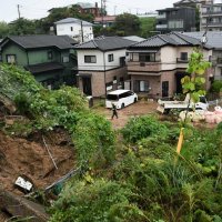 大雨の影響でのり面が崩れ、大量の土砂が住宅の手前まで押し寄せた＝８日午後３時３５分ごろ、成田市囲護台
