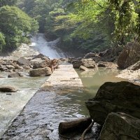 大きな岩が転がる粟又の滝付近。遊歩道右側の川岸が削り取られ空間ができている（大多喜町提供）