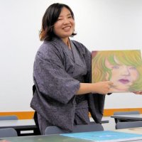 自作の絵を説明する大田垣さん。目や唇にこだわったという＝千葉市緑区
