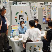 都内で開かれた「ふるさと回帰フェア」で移住を検討する人の相談に乗る長谷川さん（左から２人目）

