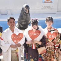笑うアシカで人気の「カンジ」と一緒に笑顔を浮かべる斎藤さん（左から２人目）ら実行委員＝７日、鴨川市