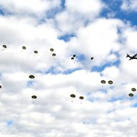 上空３４０メートルの輸送機から降下する自衛隊員たち＝７日、船橋市の陸自習志野演習場