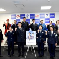 ２０２４年度の警察官採用試験の募集を呼びかけるポスターを囲む警察官ら＝県警本部