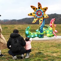 草間弥生さんの「明日咲く花」。クルックフィールズを訪れた家族連れが展示作品に見入った＝２３日、木更津市