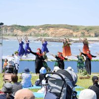 屏風ケ浦と海を背に、息の合った踊りを披露するダンサー
