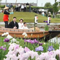 来園者から温かい祝福を受けながら、園内を舟で巡る新郎新婦＝２日、香取市の水郷佐原あやめパーク