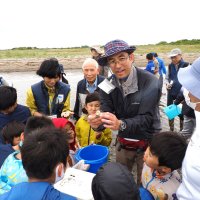 干潟の自然観察会で生物の説明を受ける参加者＝木更津市
