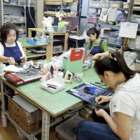 工房では刺しゅうや裏地整形などの手作業が一貫して行われている