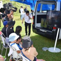 無人搬送車からの映像を見る実証実験の見学者
