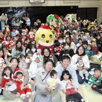 ふなっしーサンタ（中央）を囲み記念撮影する親子連れら＝２５日、船橋市