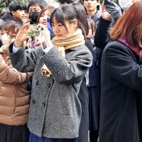 受験番号が張り出された掲示板の写真を撮る受験生や保護者ら＝４日午前、千葉市中央区の県立千葉高校