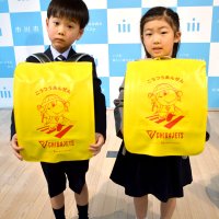 ジェッツのマスコットキャラクター「ジャンボくん」が描かれたランドセルカバーを贈られた子どもたち＝市川市