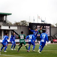 こけら落としの試合でゴール前で競り合う選手ら