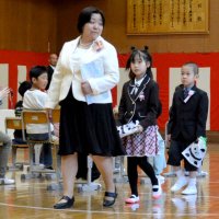 勝浦市立興津小の入学式に出席した新１年生の２人。在校生１３人が温かく迎えた＝９日、勝浦市