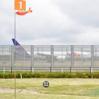 パークゴルフ場に面した成田空港の誘導路を走行する航空機
