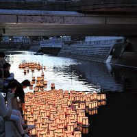 次々と真間川に流される灯籠＝１９日夜、市川市
