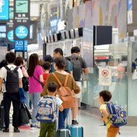 国際線に搭乗するために多くの旅客が保安検査場の列に並ぶ成田空港＝８日午後、成田市