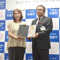 かぼすの飼い主で、切手セットの寄贈を受けた佐藤さん（左）＝佐倉市役所