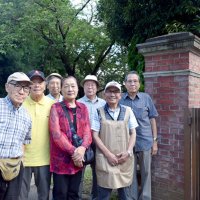 地元の歴史を後生に伝えようと活動する「習志野の歴史を語る会」のメンバー。後ろにあるのが騎兵旅団司令部の門柱＝習志野市