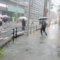 激しい雨が降り出し、足元に注意しながら急ぐ人たち＝５日午後１時前、市川市