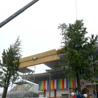 成田山新勝寺の大本堂前に飾る大しめ縄の両脇の支柱に門松を固定する工務係員ら＝２５日、成田市