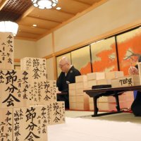 成田山新勝寺の節分会の豆まきで使用する福枡に文字を入れる僧侶＝１３日、成田市