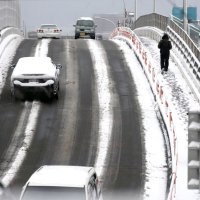 雪が降り積もった橋では減速して慎重に進む車が目立った＝８日午前８時ごろ、習志野市（画像は一部加工してあります）