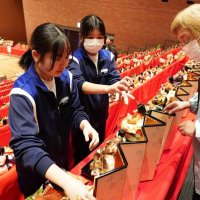 勝浦市で開かれている「かつうらビッグひな祭り」で、中学生らがボランティアに汗を流している。開幕前には市芸術文化交流センター・キュステで婦人会メンバーらと協力してひな人形を飾り付けた（写真の一部を加工しています）