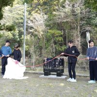 校歌と校章の刻まれた閉校記念碑の除幕式に臨む児童ら＝２１日、勝浦市立総野小

